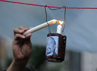 A candle is lit at a 2012 vigil for more than 20 journalists killed in Honduras over three years. (AFP/Orlando Sierra)