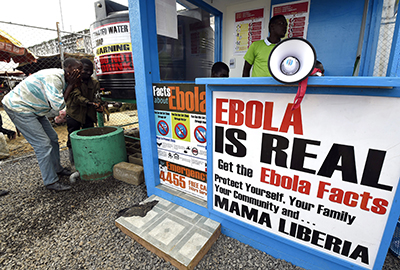 Liberians wash at an Ebola information station in Monrovia. The government has implemented restrictions on journalists reporting on the outbreak. (AFP/Pascal Guyot)