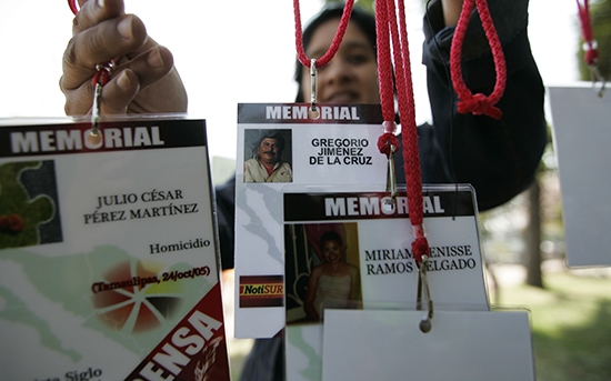 A woman holds up press IDs with the names of journalists killed in Mexico. (Reuters/Alejandro Acosta)
