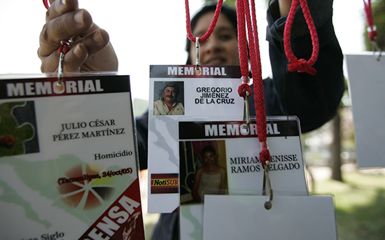 Una mujer sostiene credenciales de prensa con los nombres de periodistas asesinados en México. (Reuters/Alejandro Acosta)