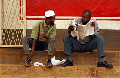 Two men read a paper in Kigali. Accreditation is voluntary for Rwandan journalists but many say it is difficult to work without a press card. (AFP/Marco Longari)