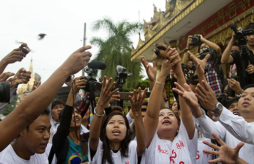 Burmese journalists release birds outside a pagoda in solidarity with five journalists who were handed 10-year prison terms of hard labor in July. (AP/Khin Maung Win)