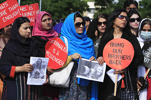 صحفيون يرفعون صوراً للمصورة الصحفية آنيا نيدريجنهاوس التي كانت تعمل مع وكالة 'أسوشيتد برس' وقُتلت في أفغانستان في أبريل/نيسان. (رويترز/ فيصل محمود)