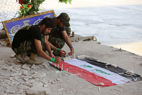 Students light candles at the edge of the Tigris to mark a June 2014 massacre of army cadets by Islamic State. As the militants are pushed out of Iraq, the toll of destruction on Iraqis, including journalists, is only just coming to light. (AFP/Ahmad al-Rubaye)