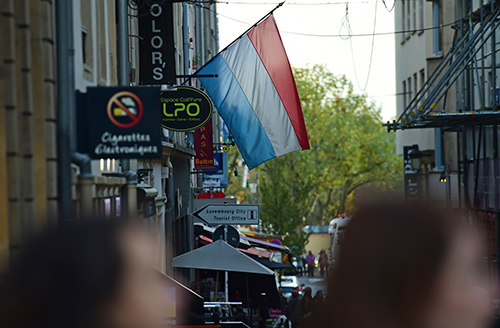 A flag flutters over a Luxembourg city street, above. French journalist Edouard Perrin, who helped expose the LuxLeaks tax revelations, has been indicted in the country. (AFP/Emmanuel Dunand)