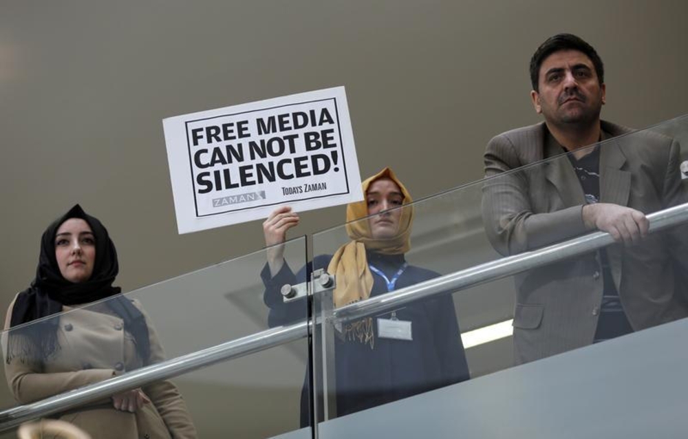 A journalist holds a placard at the headquarters of Zaman daily newspaper in Istanbul on December 14, 2014. Turkish police raided media outlets close to U.S.-based Muslim cleric Fethullah Gulen, including Zaman, and detained 23 people. (Reuters/Murad Sezer)