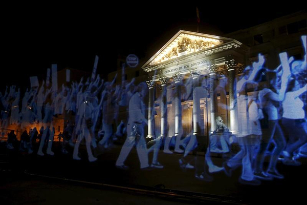 Un holograma de manifestantes es proyectado afuera de la sede del Congreso de los Diputados en Madrid el 10 de abril en oposición a la restrictiva 'ley mordaza' de España, que prohíbe manifestaciones cerca de las sedes de organismos de Gobierno y amenaza con aplicar multas por fotografiar a la policía. (Reuters/Susana Vera)