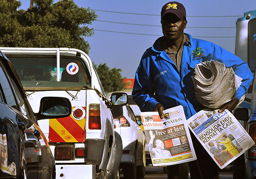Newspapers reporting on the ICC dropping charges against President Kenyatta are sold in a Nairobi street in 2014. Journalists working outside the city are more vulnerable to attacks and harassment. (AFP/Simon Maina)