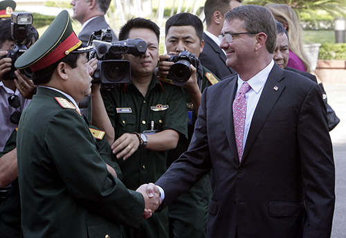 Defense minister General Phung Quang Thanh shakes hands with his U.S. counterpart, Ashton Carter, in June. Thanh says Vietnam's human rights record should not influence the U.S. ban on weapons sales. (AP/Tran Van Minh.)