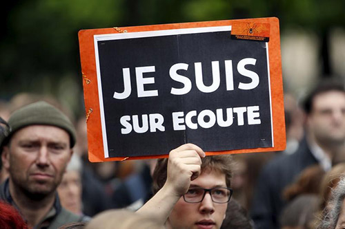 A protester holds a placard which reads 'I know they tap my phones' during a rally against the proposed surveillance bill in France. (Reuters/Charles Platiau)