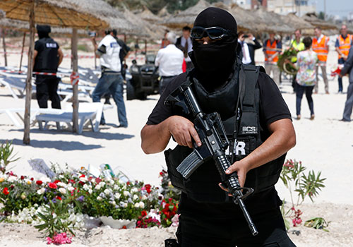 A police officer guards the Tunisian beach where a gunman opened fire on tourists in June. The media has come under pressure from authorities and extremists since the terror attack. (AP/Abdeljalil Bounhar)