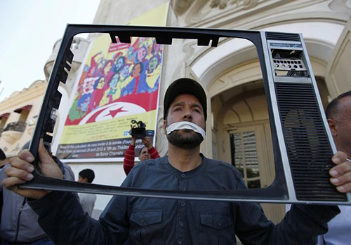 A journalist holds up a television frame during a protest in 2012. Tunisian news outlets have come under pressure in 2015. (Reuters/Anis Mili)