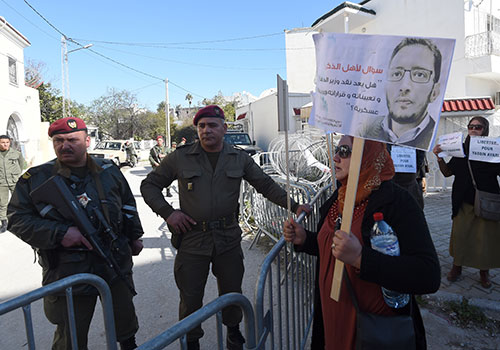 Des manifestants devant un tribunal militaire à Tunis appellent à la libération de Yassine Ayari. Le bloggeur a bénéficié d'une libération anticipée après que la communauté internationale a lancé des appels aux autorités pour le libérer. (AFP/Fethi Belaid)