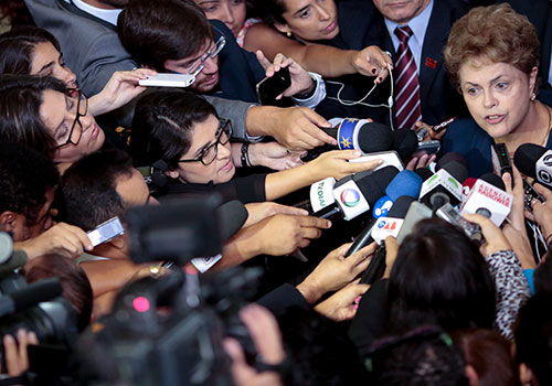 Президент Бразилии Дилма Руссеф в окружении журналистов. Несмотря на прогресс в борьбе с безнаказанностью преступников и недавно вынесенные обвинительные приговоры по нескольким делам, в Бразилии в 2015 году было убито беспрецедентное число - шесть - журналистов. (AFP/Вендерсон Арауджо)