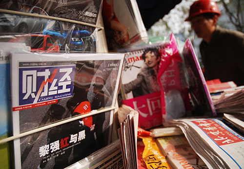 نسخ من المجلة الصينية 'كايجنغ' في كشك لبيع الصحف في بيجين. وفي أغسطس/آب 2015، اعتقلت السلطات الصينية الصحفي وانغ شياولو الذي يعمل في هذه المجلة بتهمة نشر تغطية صحفية 'غير مسؤولة' حول سوق الأسهم.  (وكالة الأنباء الفرنسية/ وانغ زاو)