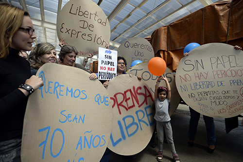 El plantel de El Nacional celebra la adquisición de papel peróiodico. La falta de papel y los controles de cambio han obligado al diario a reducir su cantidad de páginas. (AFP/Juan Barreto)