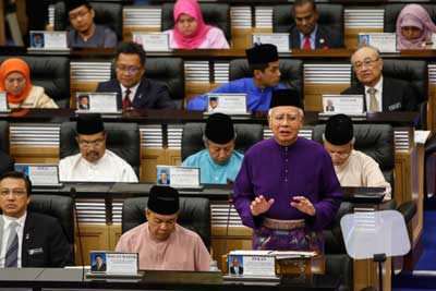 Malaysian Prime Minister Najib Razak, standing, has been cleared of wrongdoing, but the independendent media are tenaciously challenging the official narrative. (AP/Joshua Paul)