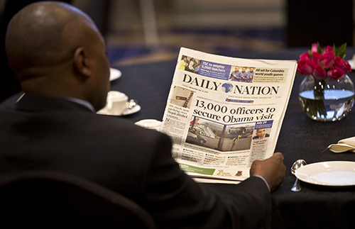A man reads a copy of Kenyan daily, the Nation. Gado, whose political cartoons were regularly featured in it, says his contract with the paper was terminated. (AP/Ben Curtis)