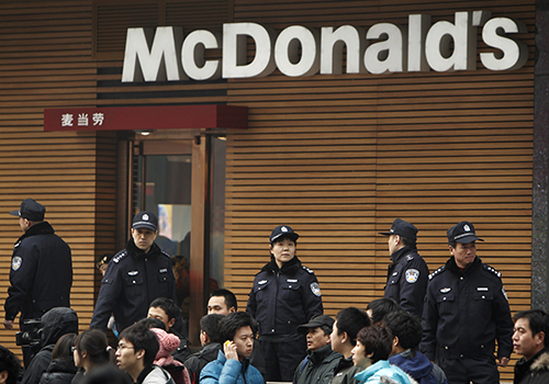 Police stand guard outside a McDonald's restaurant in Beijing in 2011. Weibo's censors were ordered to look out for posts on 'McDonald's' and 'Combo No.3' which were used as code words to plan protests in 2011. (AP Photo/Andy Wong)