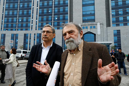 Academic and newspaper columnist Murat Belge (right) and Nobel-Prize-winning author Orhan Pamuk speak to reporters after the first session of Belge's trial in Istanbul on charges of insulting the president, May 3, 2016. (Reuters/Osman Orsal)