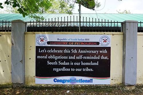 Bullet holes mark a wall where a sign celebrating five years of South Sudan's independence hangs. The country's press has come under pressure after renewed fighting. (AFP/Peter Martell)