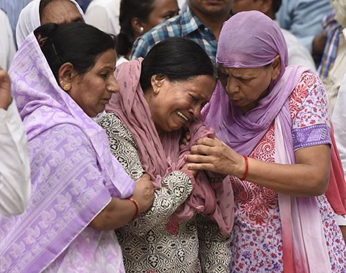 Askhay Singh’s mother is comforted at the journalist’s cremation in Delhi. Several dignitaries attended the service. (Getty Images/Hindustan Times)