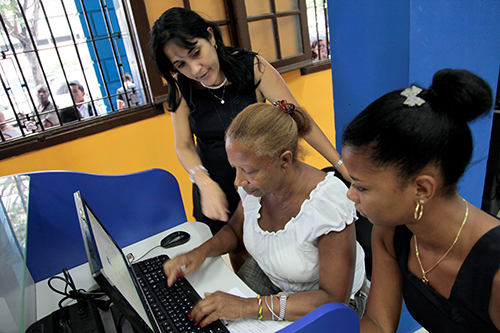 A member of Cuba’s sole internet provider, ETECSA, helps customers at a Havana cyber café. The number of publically accessible Wi-Fi spots has increased, but bloggers say more are needed. (STR/AFP)