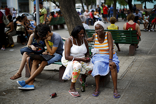 Cubans make use of a Wi-Fi access point in a square in Havana. Access to the internet costs $2 an hour. (Reuters/Ivan Alvarado)