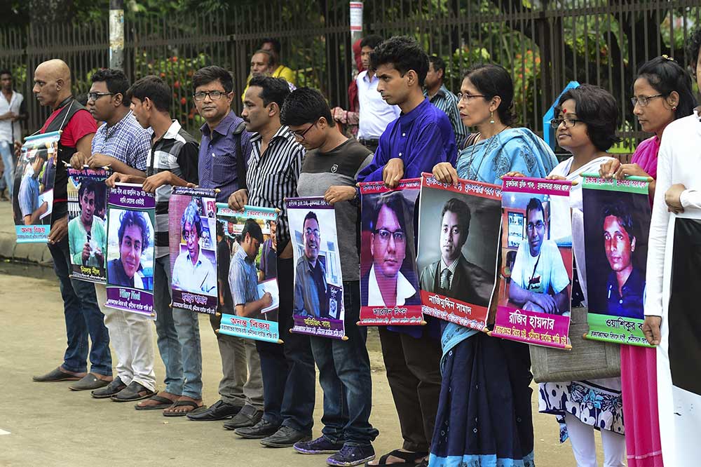 Manifestantes em Dhaka seguram fotos de ativistas e escritores mortos por extremistas. Blogueiros laicos são os jornalistas que enfrentam os maiores riscos ao trabalhar em Bangladesh. (AFP / Munir Uz Zaman)