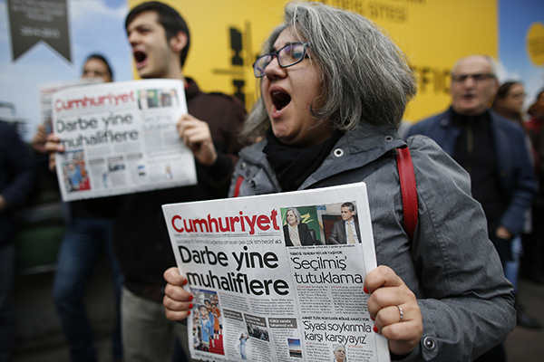 Simpatizantes del periódico opositor turco Cumhuriyet protestan frente a su sede en Estambul mientras la policía detiene a varios periodistas. (AP/Emrah Gurel)