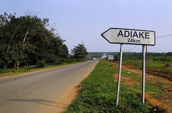 A sign for Adiake stands by an empty road in the Ivory Coast. Six journalists face charges of spreading false news for reporting on a settlement reached to end a military mutiny in the town. (Reuters/Luc Gnago)