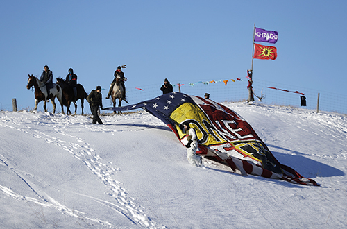 A banner is unveiled near a camp of Dakota Access pipeline protesters. Several journalists covering the Standing Rock protests are facing charges. (AP/David Goldman)V(AP Photo/David Goldman)