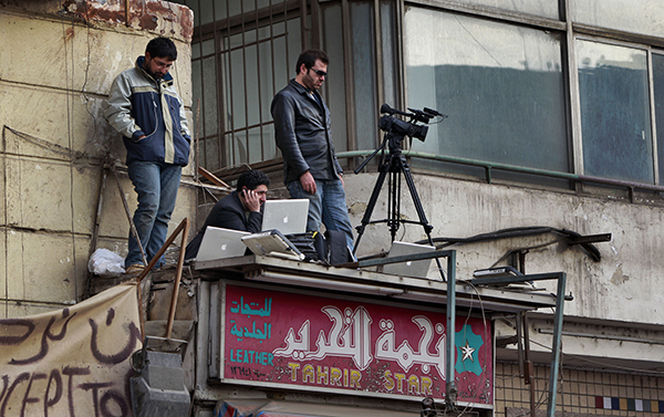 Journalists transmit footage of protests in Egypt’s Tahrir Square in February 2011. Advances in technology that bring reporters closer to the action increase the dangers they face. (AP/Ben Curtis)