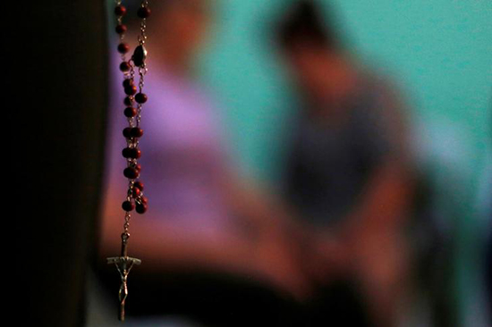 A relative of one of the men found buried in an unmarked grave in the Mexican state of Veracruz prays at a meeting in Palmas de Abajo, March 16, 2017. The state has for years been the site of violence between organized crime syndicates. (Reuters/Carlos Jasso)