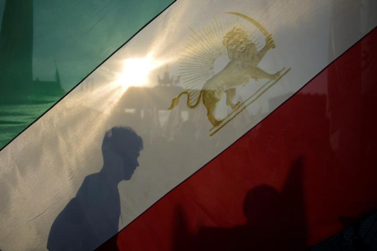 An activist holds an Iranian flag in a protest in Berlin, September 3, 2016. (Reuters/Stefanie Loos)