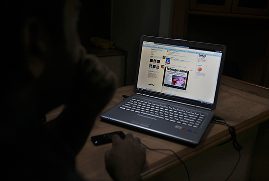 A Kashmiri youth reads a news item posted on his Facebook page in an internet cafe in Srinagar, India, August 27, 2010 (AP/Altaf Qadri)