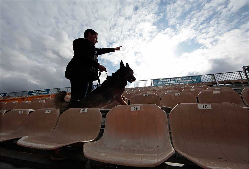 A French police officer uses a sniffer dog to check a stadium in Nice in February 2016. European cities have stepped up security measures after a series of terror attacks. (Reuters/Eric Gaillard)