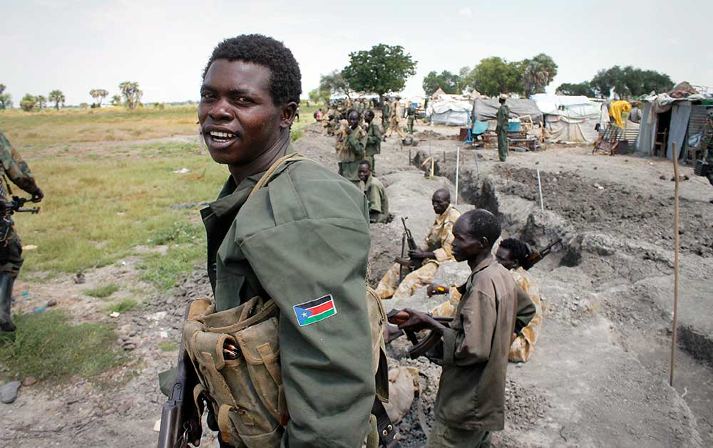 Des soldats du gouvernement sud-soudanais sont positionnés dans des tranchées à Malakal en octobre 2016. L'armée a fait venir des journalistes par avion pour leur montrer qu'ils avaient encore le contrôle de la ville, qui a été réduite en cendres et presque entièrement désertée par les civils. (AP/Justin Lynch)