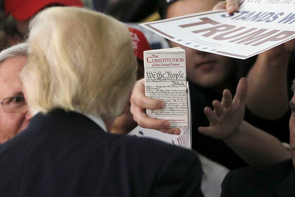 Nisan 2016'da, Donald Trump'ın Rhode Adası mitinginde kalabalıktan biri ABD Anayasası'nı gösteriyor. (Reuters/Brian Snyder)