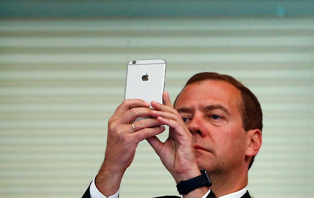 Russian Prime Minister Dmitry Medvedev uses a smartphone at the Aquatics World Championships in Kazan, Russia, in August 2015. Moscow is trying to bring the internet under its control. (Reuters/Hannibal Hanschke)