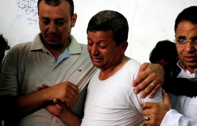 Mohammed al-Hudhaifi, the father of Takieddin al-Hudhaifi, looks at the body of his son, who was killed covering fighting in the Yemeni city of Taiz, May 26, 2016. (Reuters/Anes Mahyoub)