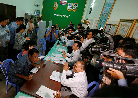 Journalists crowd around Cambodian Prime Minister Hun Sen in the province of Kandal, September 1, 2016, as he registers to vote in local elections scheduled for June 4, 2017. (Reuters/Samrang Pring)