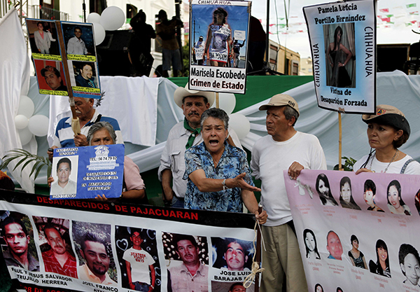 Manifestantes sostienen imágenes de víctimas de los carteles del narcotráfico y las pandillas en Oaxaca en 2011. El estado es escenario de una creciente operación de narcotráfico que ha aumentado el índice de homicidios. (AP/Eduardo Verdugo)