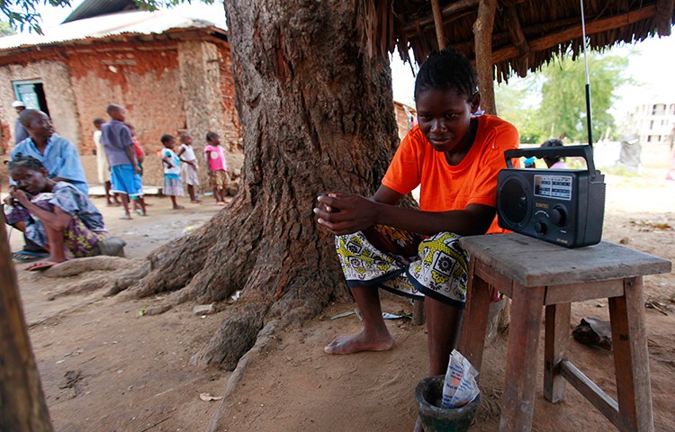 A young Kenyan listens to the news on the radio in this March 2013 file photo (Reuters/Joseph Okanga)