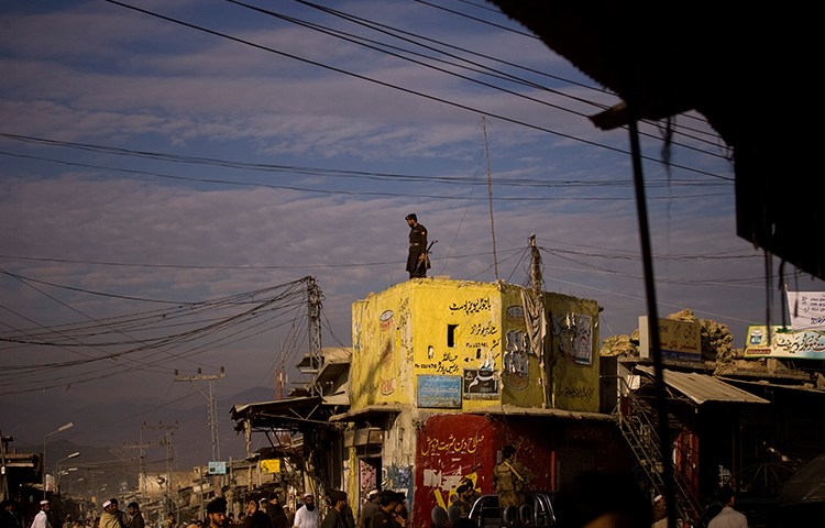 In this November 29, 2008, file photo, a member of the Frontier Corps paramilitary group surveys a street in Khar, Pakistan. (AP/Emilio Morenatti)