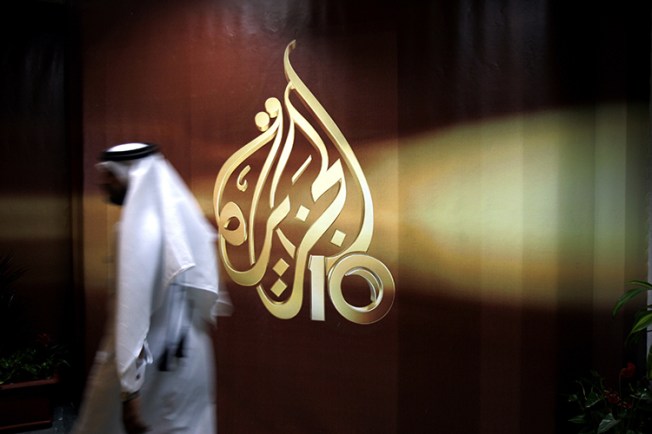 A Qatari employee of Al-Jazeera walks into its Doha headquarters in this 2006 file photo (AP/Kamran Jebreili)