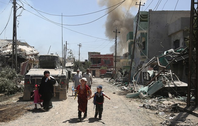 Iraqis flee their Mosul homes during fighting in May. Local journalists say they went into hiding to survive during the takeover by Islamic State militants. (AFP/Ahmad Al-Rubaye)