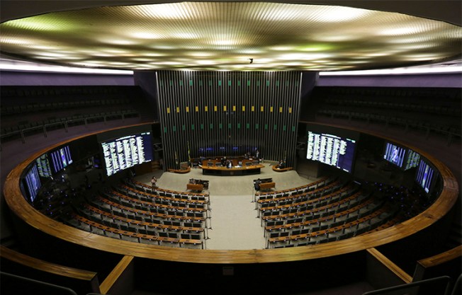 A Câmara dos Deputados do Brasil realiza uma sessão em 12 de abril com apenas dois deputados depois que o Supremo Tribunal Federal anunciou investigações de corrupção envolvendo vários políticos. Um jornalista perguntou por que o tribunal divulgou detalhes de seu telefonema com uma fonte, apesar de ele não fazer parte da investigação. (AP / Eraldo Peres)