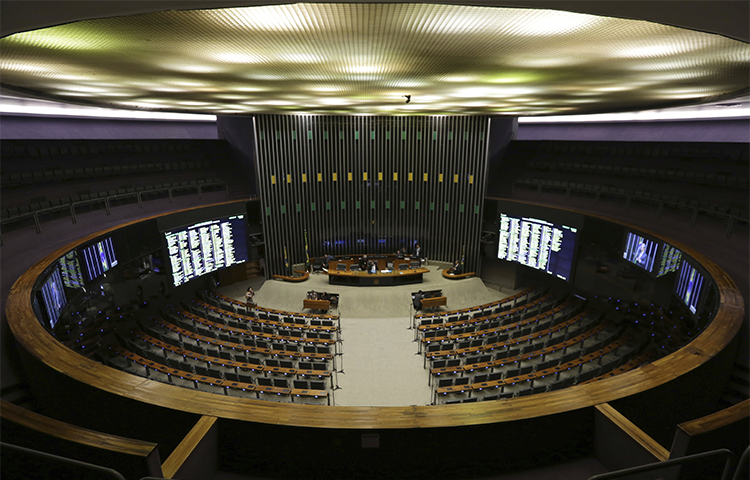 A Câmara dos Deputados do Brasil realiza uma sessão em 12 de abril com apenas dois deputados depois que o Supremo Tribunal Federal anunciou investigações de corrupção envolvendo vários políticos. Um jornalista perguntou por que o tribunal divulgou detalhes de seu telefonema com uma fonte, apesar de ele não fazer parte da investigação. (AP / Eraldo Peres)