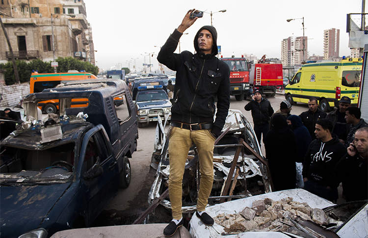 An Egyptian uses his phone to record the aftermath of a deadly explosion outside a police headquarters in December 2013. Journalists who use smartphones and messaging apps in their reporting say they are wary of surveillance and trolling under Egypt's press crackdown continues. (AP/Ahmed Ashraf)